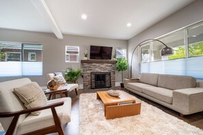 Relax in a mid-century living room while reading a book, enjoying the views of o