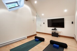 Top floor yoga room with two yoga mats, a large TV, BluRay player, and Bose sound system