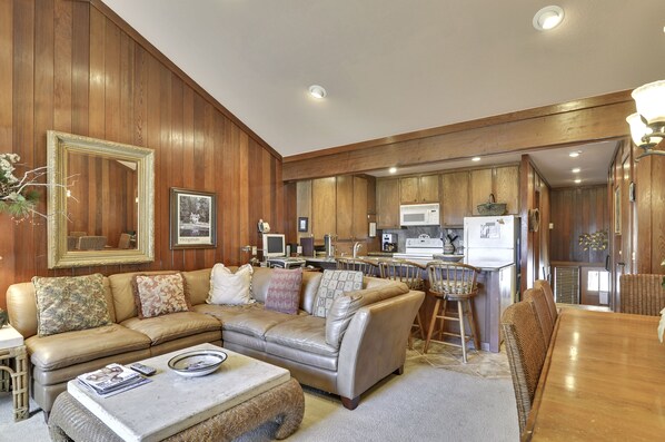Living room area with a new sofa, dining room with a sitting for 8 and kitchen - all overlooking the lake.
