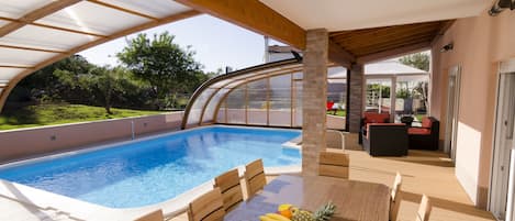 Swimming pool area with an open swimming pool shade and big outside dinning tabl