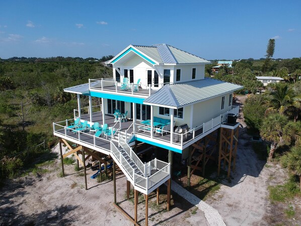 Beach view of house. Shows sundecks and lanai.