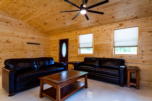 Living room with leather couches and cathedral ceiling