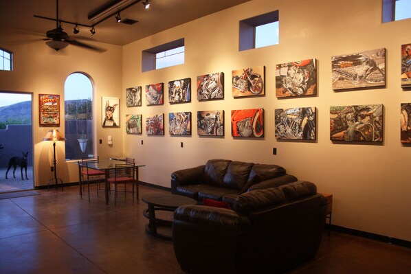 Main room full of motorsport artwork. Lighting, Ceiling fans, Stained floors.