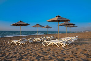 Private sun beds on the sandy beach, 100 meters away