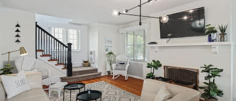 Living room with plush area rug, 55" Smart TV and leather sectional