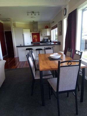 Dining table and chairs with kitchen in the background.