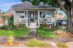 Front Porch—Features a porch swing, wicker chairs, tables and candles for summer nights. Prairie plants and grasses feed the birds and bees. We love the luscious no-mow lawn!