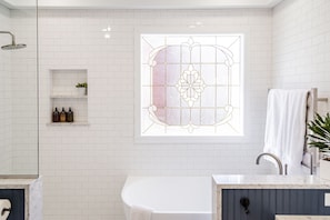 Full Bath—Featuring a soaking tub, heated floors, a rain head shower, and a towel warmer.