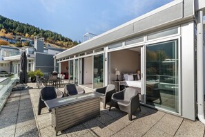 Outdoor balcony with mountain and lake views, along with a gas fire table