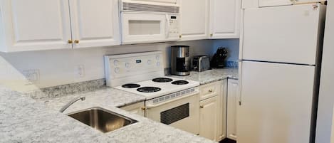 Full kitchen featuring white cabinets and countertop