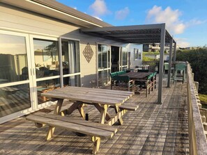 Large deck with ample seating and louvred pergola for all weather dining.