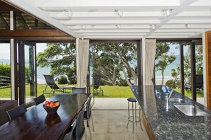 Large marble kitchen island bench separates the kitchen from the dining area