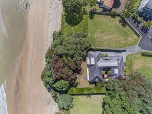 Lawn on 3 sides and ancient Pohutukawa between the house and sand.