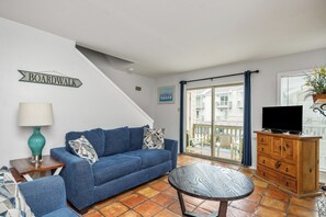 Living area with a queen size sleeper sofa and flat screen TV, offering private balcony