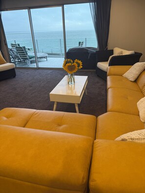 Lounge area looking out onto front patio and sea and Mountain View