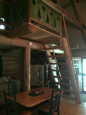 Stairs to loft sleeping area, with privacy curtain open -- located behind beams.