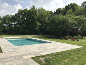 Une piscine douce, posée sur le gazon, presque dans les champs.