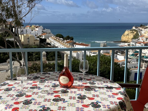 A Glass of Wine Overlooking The Ocean & Village below.