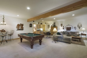 View into the recreation room with pool table, large sectional sleeper sofa with queen-size pull-out, flat screen, card table, mini bar, and full bathroom.