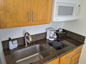 Small kitchen in studio with single burner cooktop.