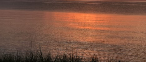 Views of the Chicago skyline across the lake while the sun sets.