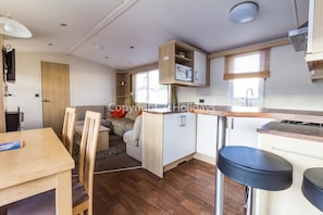 The kitchen has a mini breakfast bar as well as a dining table ideal for families!