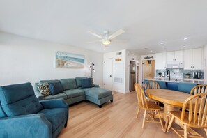 Spacious living area with cozy furniture, bright light shining in and new features throughout
