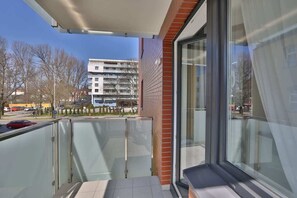A private balcony with a small seating area, perfect for relaxing outdoors with views of the surrounding area.