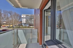 A private balcony with a small seating area, perfect for relaxing outdoors with views of the surrounding area.