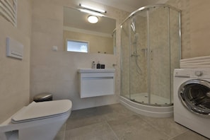 A bathroom featuring modern fixtures, including a sink, toilet, and a heated towel rack.