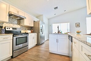 Fully equipped modern kitchen with stainless steel appliances and ample countertop space.