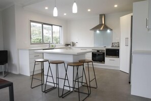 Open plan kitchen, with sliding windows out to the BBQ for easy serving. 