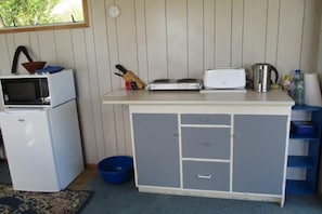 The kitchen. Bench, sink and water outside.