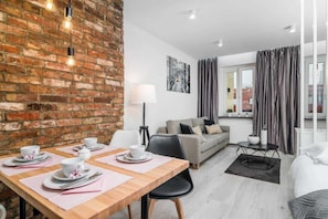 Studio: Living room with fold out sofa bed and double bed, dining area and tv