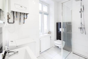 Bathroom with washing machine and towels. 