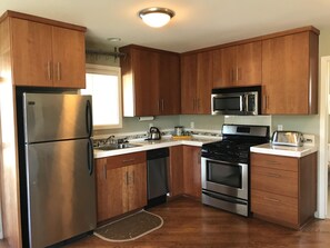 Kitchen with dishwasher, oven, microwave, full-size refrigerator.