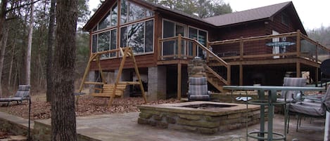 Rock patio with fire pit is just below the deck. 