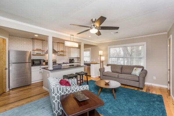Modern, open kitchen/living area with large TV