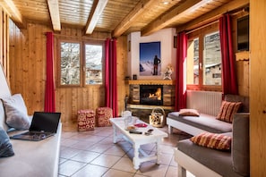 Le salon chaleureux et sa cheminée dans le Snow Paradise au Bettaix