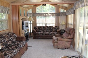 Living room area with 2 pull out couches, electric fireplace, tv, dvd player