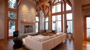 Living room with vaulted ceilings, fireplace, and TV