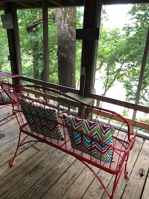 The screened-in porch overlooks the boat dock and the river. 