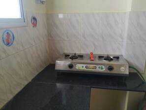 kitchen with gas stove, cooking utensils, coffee kettle, tumblers, mineral water