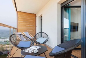  A cozy balcony setup with two black chairs and a small coffee table, offering a relaxing outdoor space.