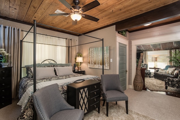 Bedroom area with king poster bed, ceiling fan and on each side bed