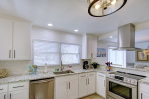 Open Kitchen • Granite Counters • Stainless Appliances - Bright and functional, this fully equipped kitchen features granite countertops, stainless appliances, and a full coffee setup by the window. Whether you're prepping dinner or brewing your morning cup, it’s ready for whatever your crew has planned.