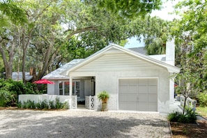 Classic Coastal Exterior • Quiet Street • St. Simons Rental - The front view of Sea Glass Cottage—a classic St. Simons retreat tucked on a quiet residential street just 2 blocks from the beach. With fresh landscaping, private parking, and a fully fenced yard, this home blends island charm with everyday convenience.