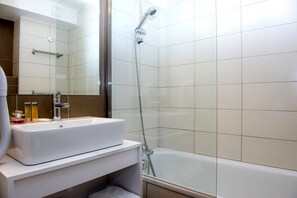 This bathroom features a shower and tub combination.