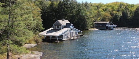 Small boathouse in foreground, large boathouse in background