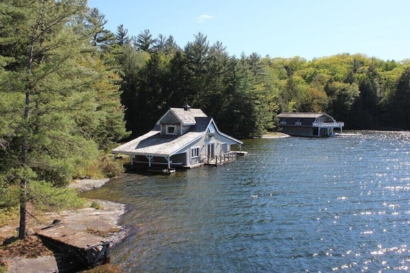 Small boathouse in foreground, large boathouse in background